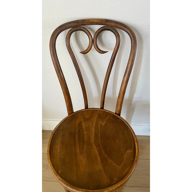 A classic pair of bistro chairs with wooden seats, likely created by Michael Thonet and manufactured in the ZPM Radomsko...