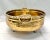 A striking hammered brass oval cachepot featuring sculpted feet and elegant side handles. The warm patina and hand-...