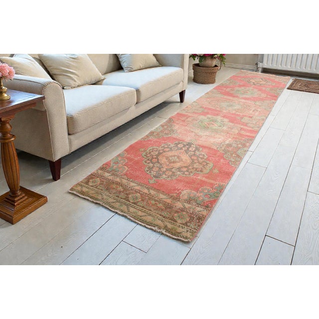 This is a vintage Turkish Oushak rug from the Mid 20th Century. The piece was hand-knotted.