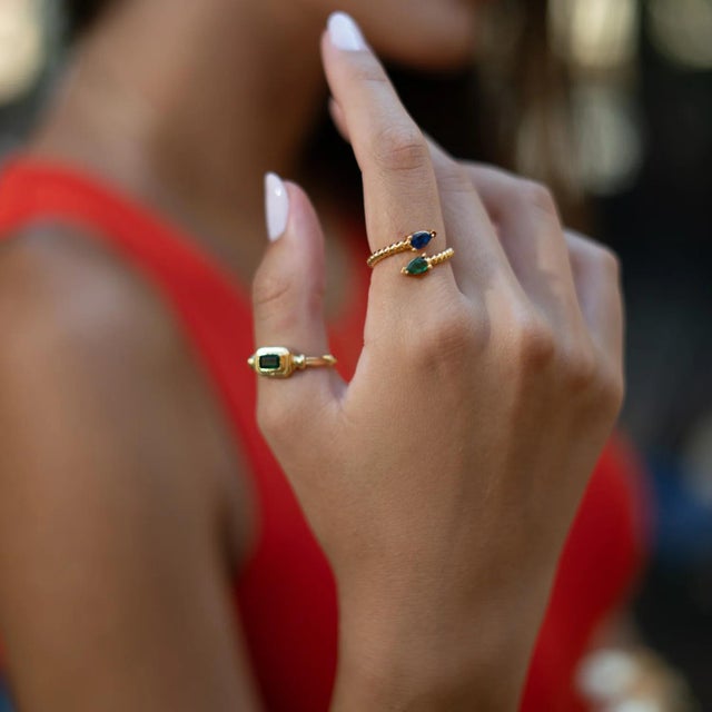 Discover balance and beauty with the Sapphire & Emerald Teardrop Glow Gold Adjustable Ring. This striking design pairs the...