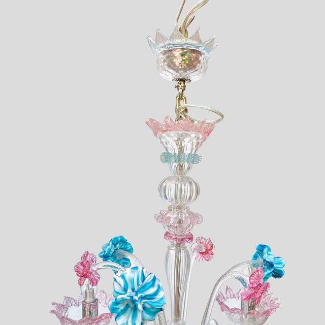 A Venetian chandelier. Blown glass three arms with blue, pick and clear glass decoration designed and executed in Murano...