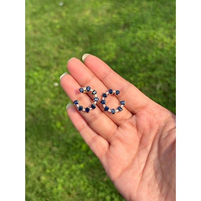 These striking bold geometric statement open hoop earrings showcase 16 octagon-cut blue sapphires totaling 4.07 carats,...