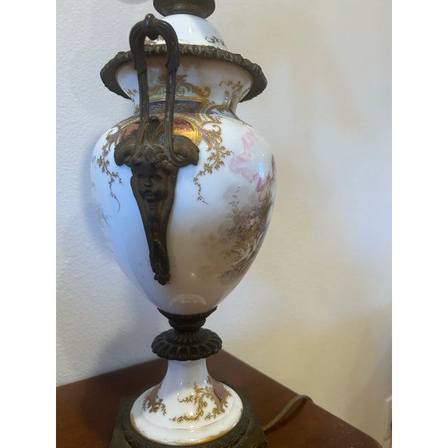 Circa 1920 French Sevres Urn Lamp. Hand painted a figurine and an angela white background and pink and light blue accent....