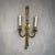 A pair of electrified gilt brass sconces in the timeless French Neoclassical style. Tassle-forms bound and draped, holding...