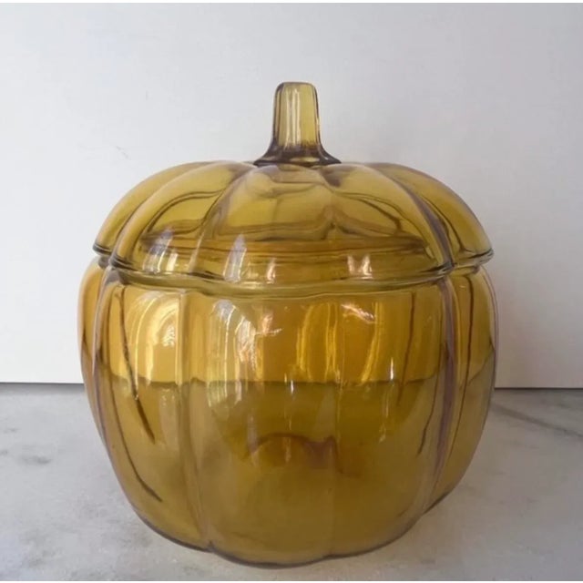 This large glass pumpkin bowl 7" tall with the lid and 7" in diameter at the widest point. It is a yellow glass piece and...
