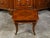A walnut coffee table from the mid 20th century, with geometric star-inlaid top and curving legs. Created during the...