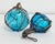 Vintage pair of inspired glass fishing buoys with hand-tied rope net and handle. Hand-blown aqua blue glass. Small buoy...