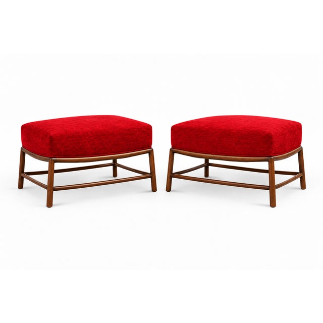 A handsome pair of mid-century style ottomans featuring generously padded seats in vibrant red textured upholstery. Softly...
