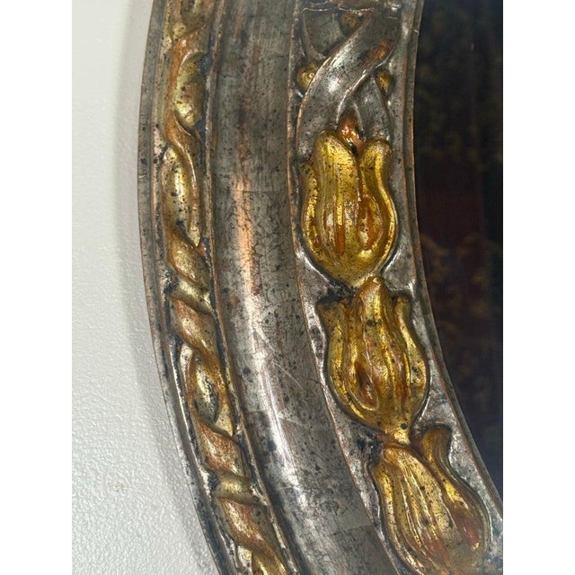 A beautifully executed Italian oval mirror, crafted in Florence and finished in a rich combination of burnished silver...