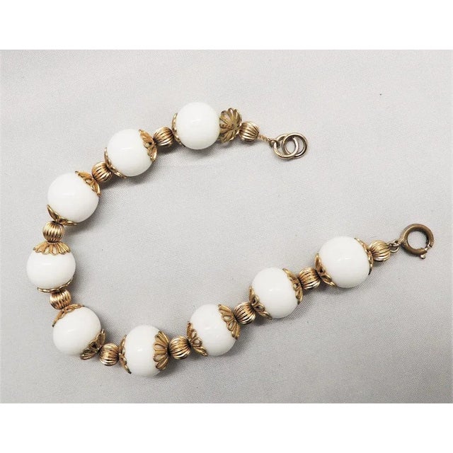 This is part of Chairish’s Costume Jewelry assortment. 1950s goldtone white resin beaded bracelet with goldtone mellon...