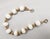 This is part of Chairish’s Costume Jewelry assortment. 1950s goldtone white resin beaded bracelet with goldtone mellon...