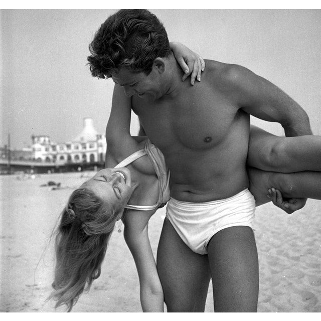 Muscle Beach Santa Monica LOS ANGELES - JULY 24: A muscle builder man holds up a woman behind his back at Muscle Beach on...