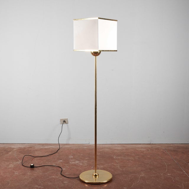 This floor lamp, with its evident signs of age, is a designer piece that tells a story. Its slender structure and square...