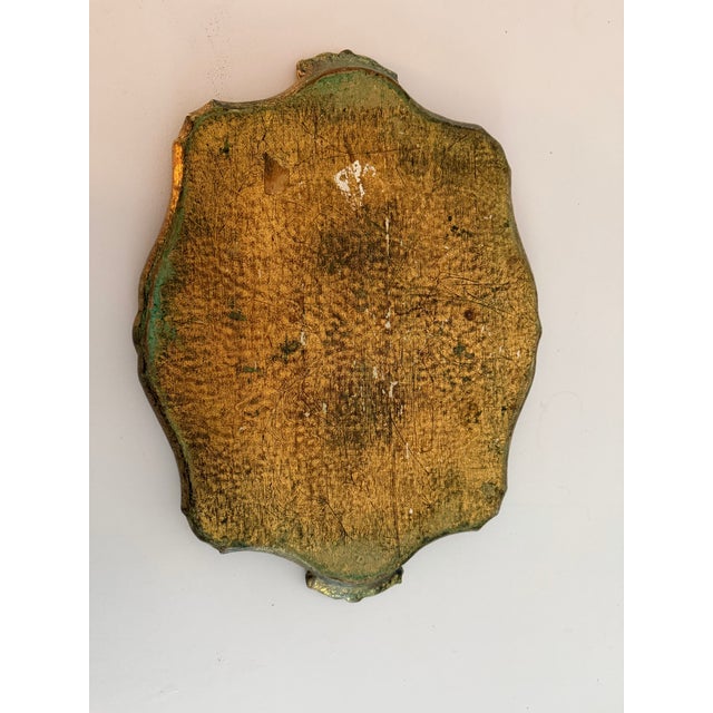 This is a vintage Italian Florentine wooden tray featuring distressed gold gilt and painted details. The patina created...