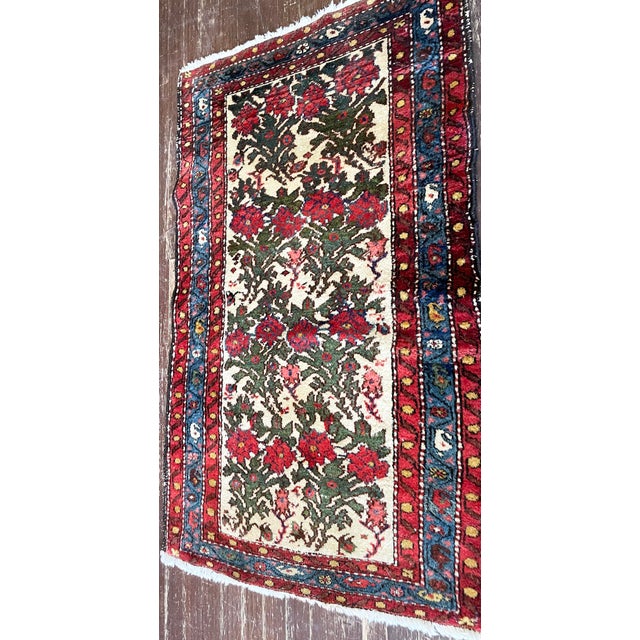 A charming antique Persian Bakhtiari rug featuring an ivory field filled with an all-over floral pattern of stylized...