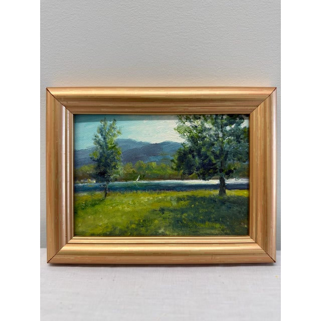 A serene original landscape painting by Gary Dagnan depicting a calm lakeside scene framed by sunlit trees and distant...