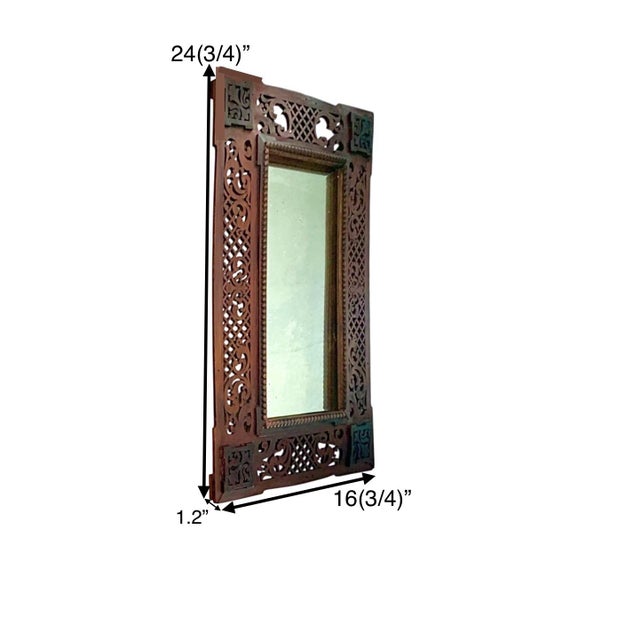 This antique Moroccan hand-carved lattice mirror features a stunning red wood frame, adding a touch of elegance and style...