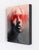 In "Cipher," the figure emerges from a soft, blurred background, its features partially obscured by bold strokes of red...