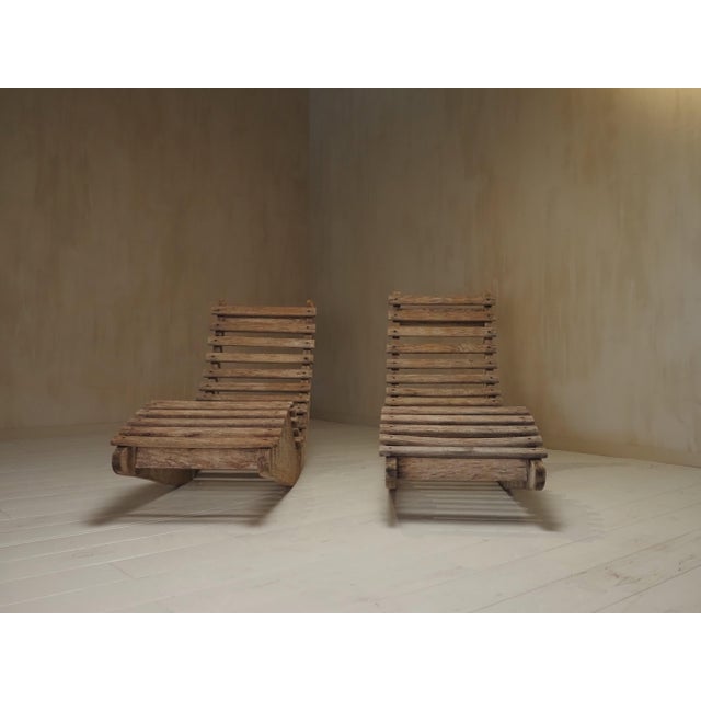 A striking pair of French Mid-Century Modern garden lounge chairs crafted from solid teak. Featuring a sculptural, low-...