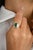 This 18k gold statement ring showcases an octagon-cut center emerald, surrounded by a dazzling baguette-cut diamond halo....