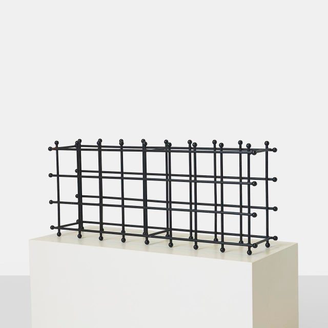 Description Modernist Iron Wine Rack A sculptural iron wine rack with plastic ball caps with storage for 24 bottles. Can...