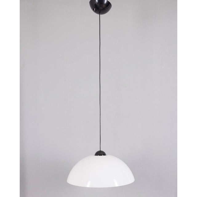 Pendant lamp with hemispherical diffuser in white plastic and upper support in black plastic, designed by Martinelli Luce,...