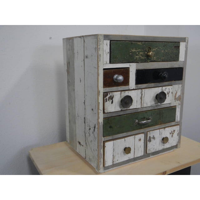 Made of fir wood and lined with reclaimed wood. It features 8 drawers of various sizes. Original handles in iron, brass,...