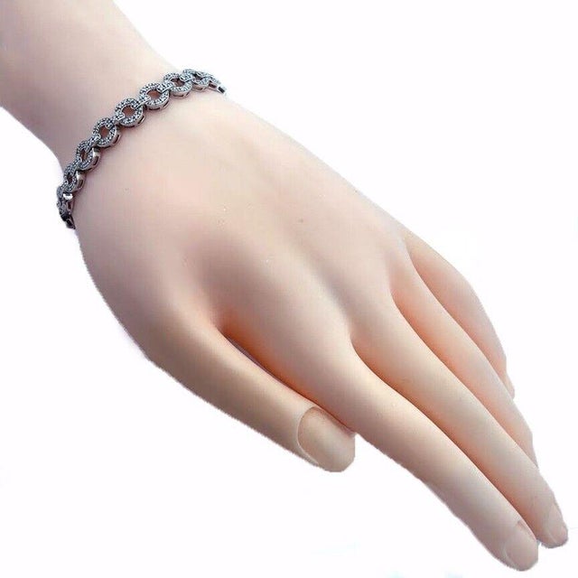 This elegant bracelet is crafted from 14k white gold featuring alternating round and short bar links all with pave set...