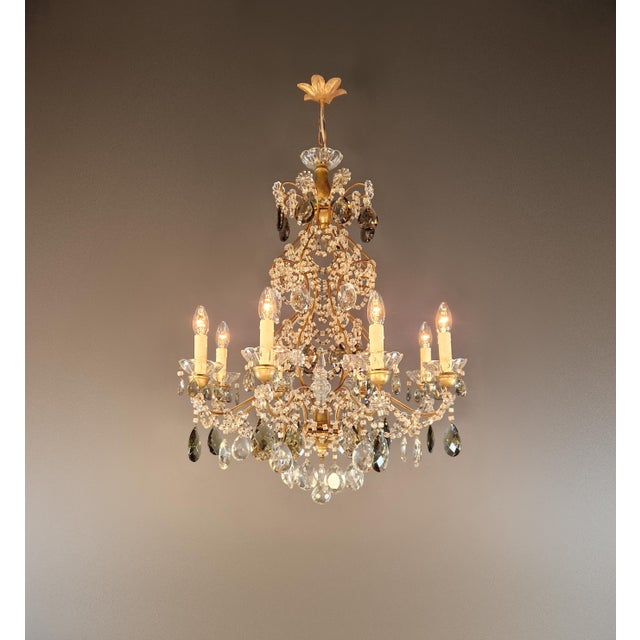 This antique chandelier captivates with its diverse crystal ornamentation and combination of various materials....