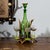 Green glass decanter with cut decoration and six liqueur glasses with green stems in a hunting-style bottle holder. The...