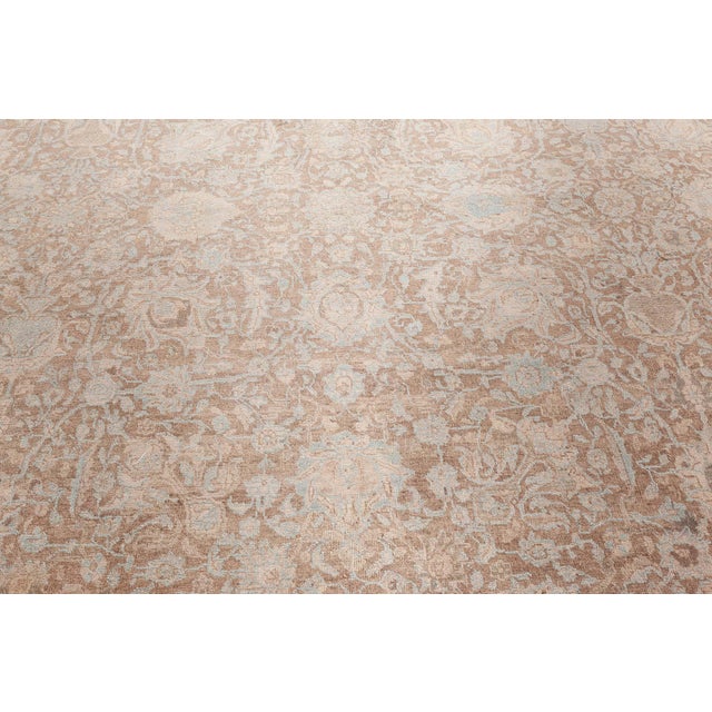 The early 20th century antique Tabriz Persian rug features a strikingly elegant all-over palmette trellis design...