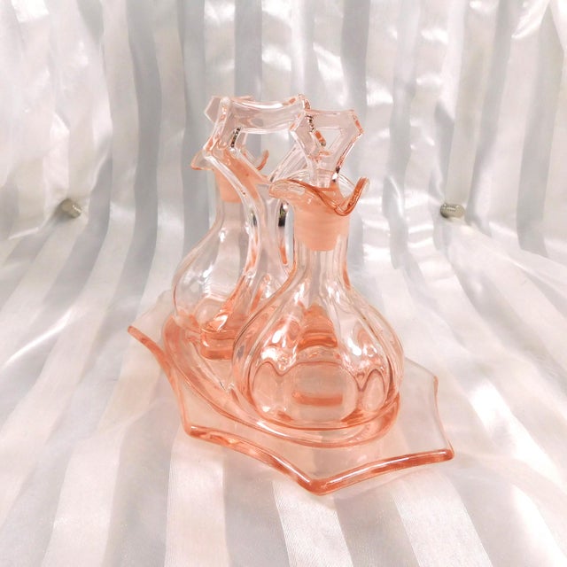 This is a pink glass five piece set of two jars, two stoppers and a matching tray. I am not sure if it is a vanity tray...