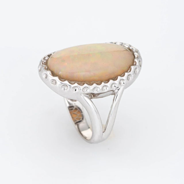 Stylish natural 8ct opal cocktail ring crafted in 14 karat white gold. Cabochon cut natural opal measures 20mm x 12mm...