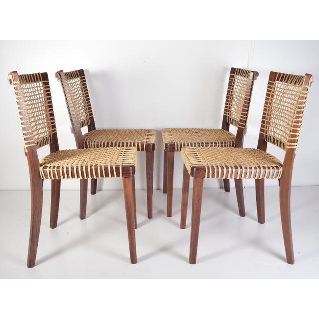 Bring an organic, highly textured look to your dining room with this rare set of four raffia-woven dining chairs....