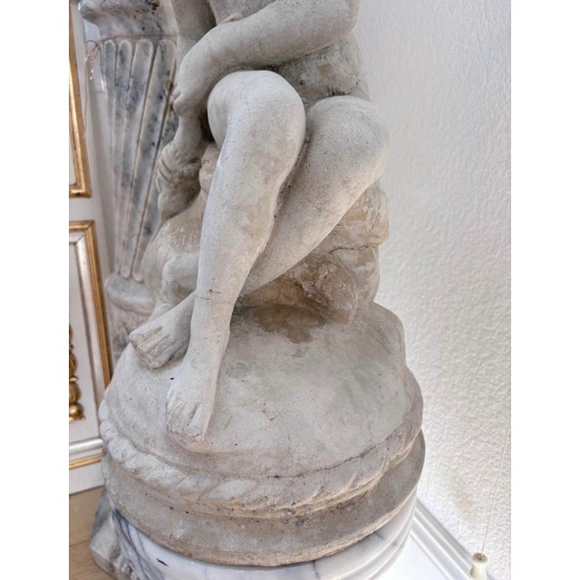 Charming classical garden sculpture depicting a seated maiden in a contemplative pose. Crafted from cast stone with a...