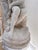 Charming classical garden sculpture depicting a seated maiden in a contemplative pose. Crafted from cast stone with a...