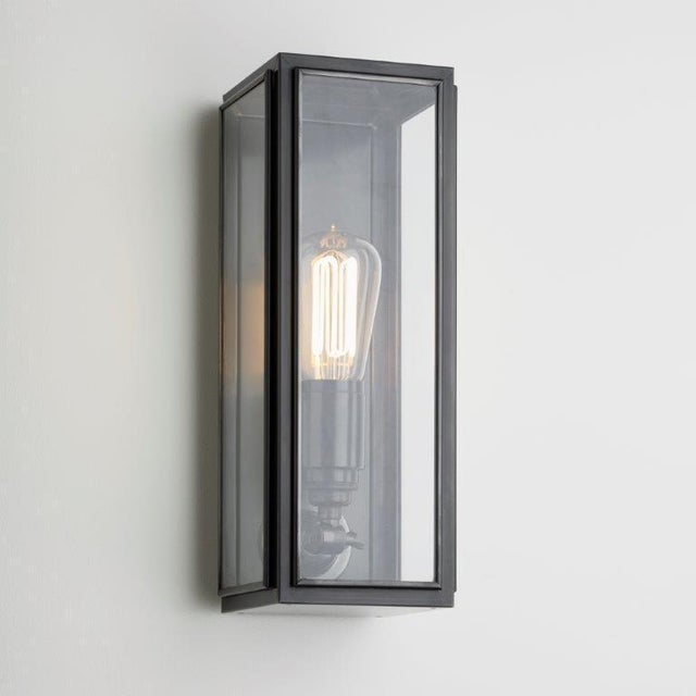Wall light in brass with outside fitted clear or frosted glass. Spring closure. For indoor and outdoor use (IP44). Caret...