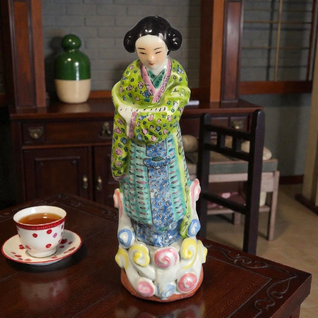 The product is a vintage Chinese Famille Rose porcelain figurine, hand-painted with intricate details depicting...