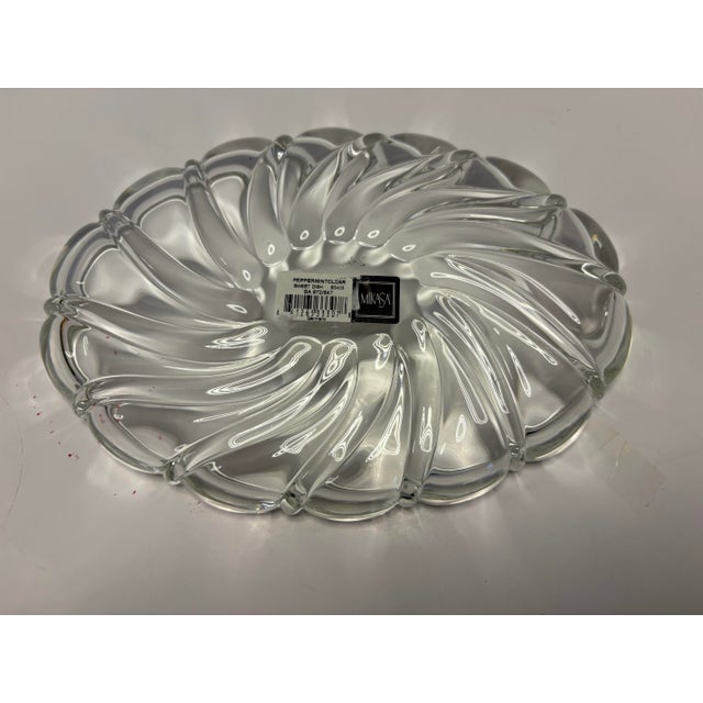 A sculptural Mikasa Peppermint Clear crystal sweet dish featuring a dynamic swirling interior and scalloped rim. Made in...