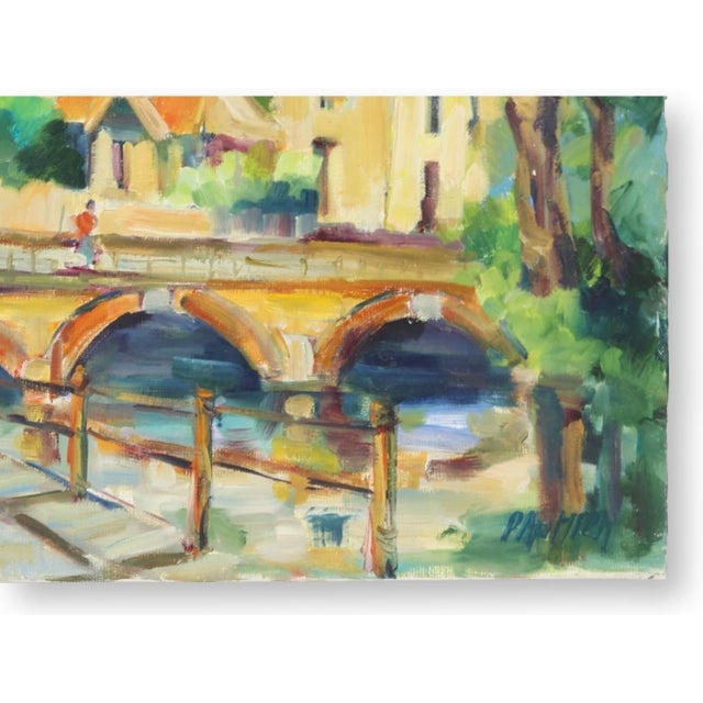 Original oil on canvas by French artist Liliane Paumier depicting a charming village along a canal with a stone bridge,...