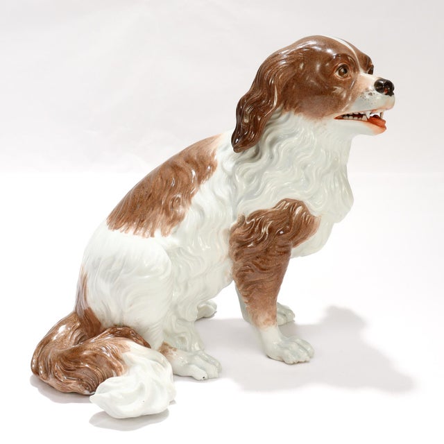 A fine antique porcelain dog figurine or sculpture. Attributed to one of the Dresden factories. In the form of a King...