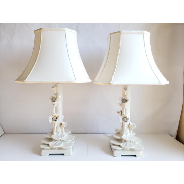 Vintage Hollywood Regency style Faux bamboo and Lotus flowers Italian white ceramic lamps. The fabric shades are 18" W x...
