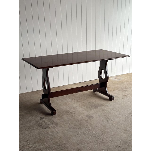 This vintage old world oak dining table features a sculptural trestle base with pierced pedestal supports, exposed joinery...