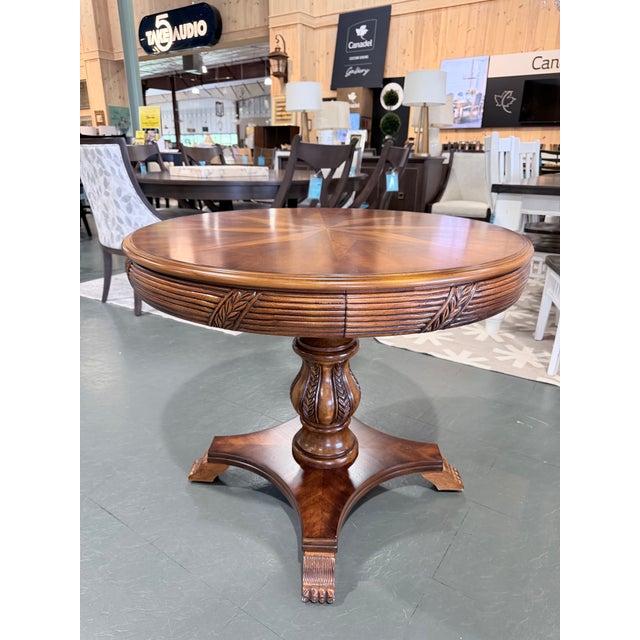 A distinguished vintage accent table showcasing exceptional craftsmanship and timeless traditional styling. The circular...