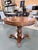 A distinguished vintage accent table showcasing exceptional craftsmanship and timeless traditional styling. The circular...