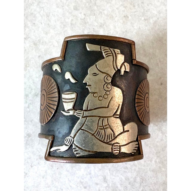 Vintage solid copper cuff bracelet featuring a raised silver Mayan or Aztec-style figure.