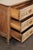 A French carved wood chest of three drawers from the early 19th century. This antique commode from France features a...