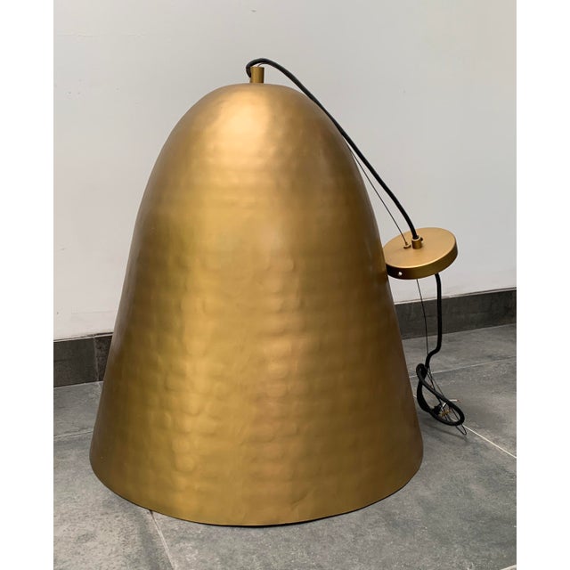 Extra large, hand hammered brass dome pendant light by CB2 with a silver foil interior that shimmers when the light is...