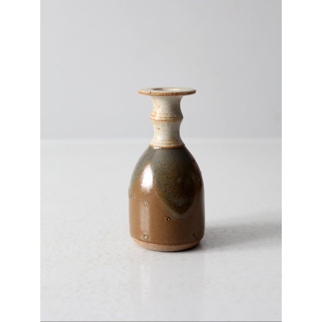 This vintage studio pottery vase is hand-thrown and signed by the artist. Its organic form is complemented by a mottled...