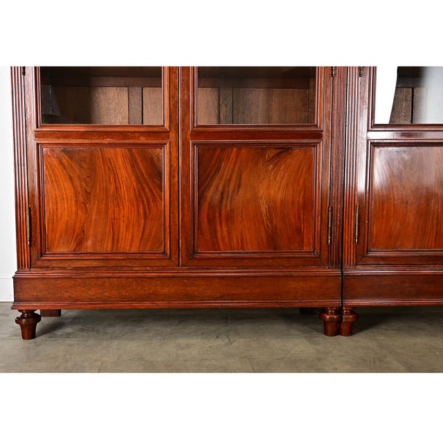 A sprawling, 19th century French bibliothèque, handcrafted of mahogany with four glass-front doors to display treasured...
